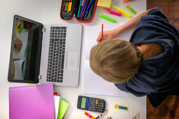 istock Overhead view on schoolboy writing his homework. 1280937007