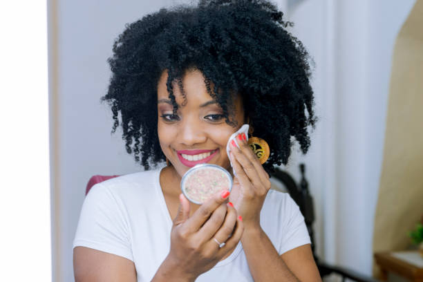 istock Young black woman taking off makeup with white cleaning tissue. 1280937720
