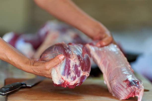 istock Woman's hand slicing beef on a wooden board 1280938046