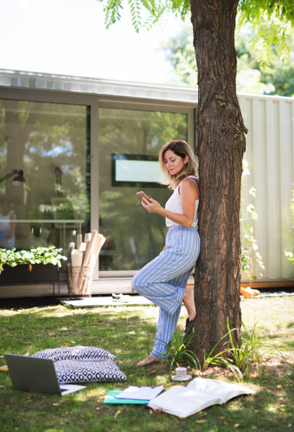 istock Mature woman working in home office outdoors in garden, using smartphone. 1280938062