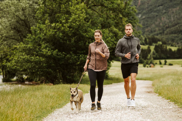 istock Young couple running with their dog 1280938124