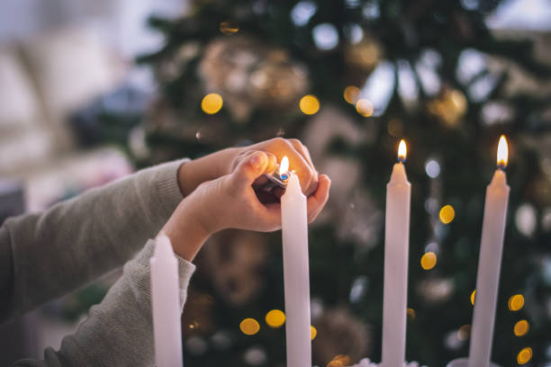 Christmas detail, lightning candles. Kid enjoy in living room during Christmas Celebration, Cheerful Christmas time stock photo