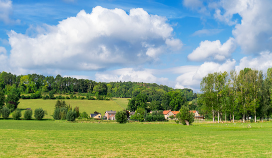 A typical landscape of Limburg, Netherlands, with rolling hills under a nicely clouded sky. The location is near Stokhem