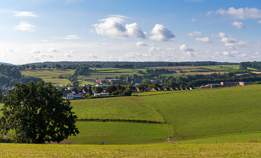 A typical landscape of Limburg, Netherlands, with rolling hills under a nicely clouded sky. The location is near Gulpen