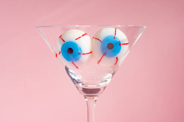 Creative Halloween layout with eyeballs in martini glass. Minimal holiday concept.