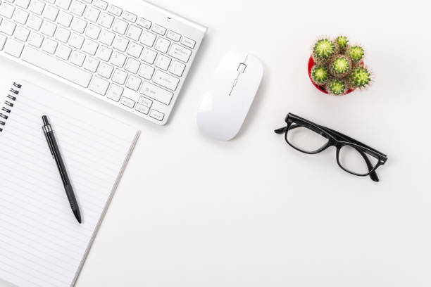 istock White office desk table with blank notebook, computer keyboard and other office supplies. Top view with copy space. 1280941096