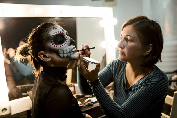 profesjonalny makijażysta malowanie twarz kobiety na halloween noc party - makeup artist zdjęcia i obrazy z banku zdjęć