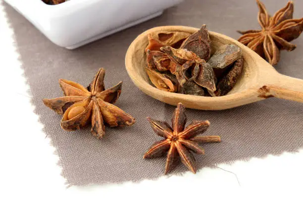 Detail of star anise in a wooden spoon