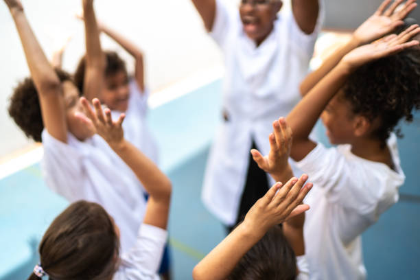 istock Teacher and students - teamwork huddling before sports game in school 1280944323