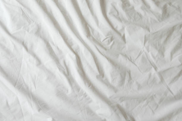 istock Background of white rumpled sheets. Bed linen with wrinkles in day light. Horizontal. Copy space. Concept of rest, awakening, sleep, stay at home. For social media, blog 1280946193