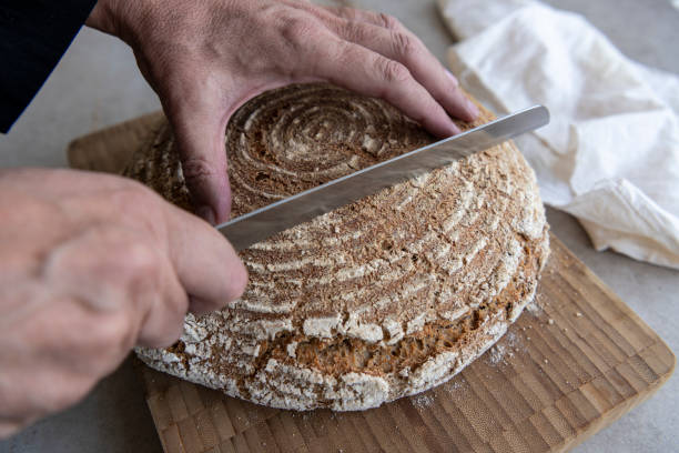 istock Chef is cutting crispy bread just out of the oven 1280949971
