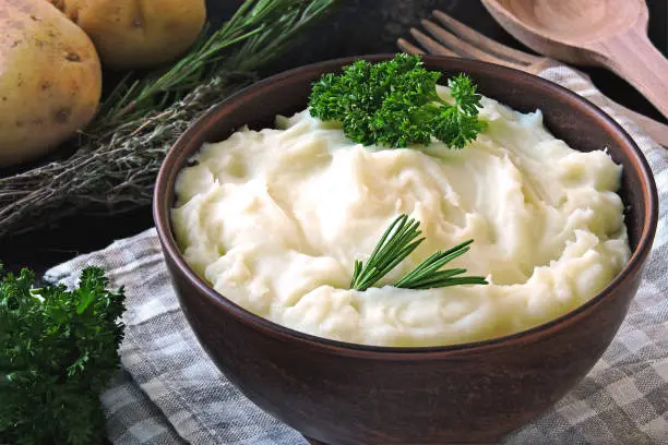 Rustic kitchen. Fresh potato dish. Mashed potatoes in a bowl. Homemade mashed potatoes with fragrant herbs. Fresh homemade mashed potatoes with aromatic herbs and sea salt.