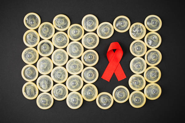 istock AIDS ribbon with condom on black background 1280950864