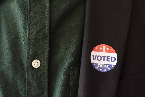 He votado hoy pegatina en la solapa del abrigo de un hombre para las elecciones presidenciales de EE.UU. photo