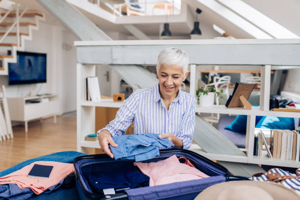 istock Mature woman preparing her suitcase for a travel 1280952296