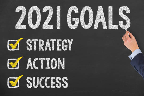istock Human Hand Writing New Year 2021 Goals on Chalkboard Background 1280953528