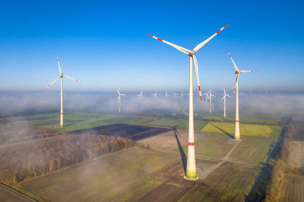 Aerial view of wind turbines Aerial view of wind energy turbines on windfarm above mist layer on german countryside in the morning sun. Germany landscape alternative energy scenics farm stock pictures, royalty-free photos & images