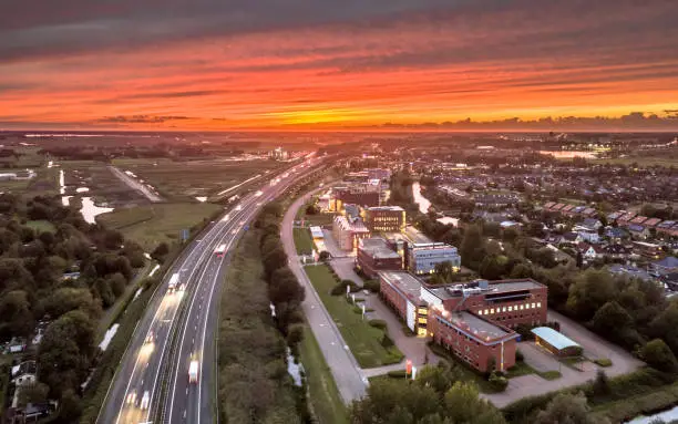 Aerial View over motorway A7 entry point on the west side of Groningen city under orange sunset. Netherlands