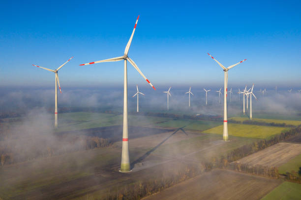 Aerial view of wind turbines Aerial view of wind energy turbines on windfarm above mist layer on german countryside in the morning sun. Germany landscape alternative energy scenics farm stock pictures, royalty-free photos & images