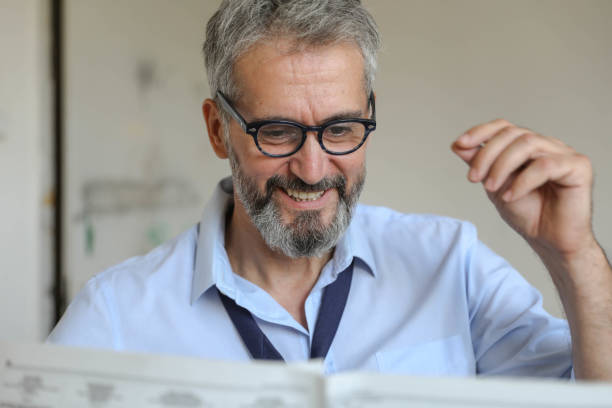 istock Senior Man is Reading Newspaper at Home, Close up 1280958398