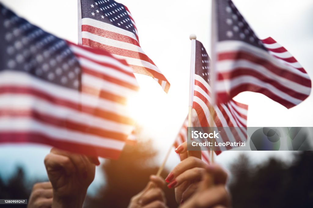 Crowd celebrating with national US flag Group of people celebrating with national US flag American Flag Stock Photo