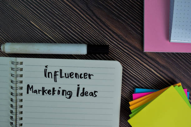 istock Influencer Marketing Ideas write on a book isolated wooden table. 1280960155