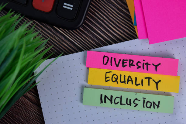 diversity equality inclusion schrijven op een kleverige noot geïsoleerd op office desk. - diversiteit stockfoto's en -beelden