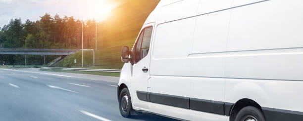 istock White modern delivery small shipment cargo courier van moving fast on motorway road to city urban suburb. Busines distribution and logistics express service. Mini bus driving on highway day. banner 1280960928