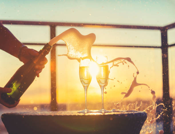 champagner wird geöffnet und explodiert mit blasen. es gibt auch 2 champagnergläser. - champagnerfarbig stock-fotos und bilder