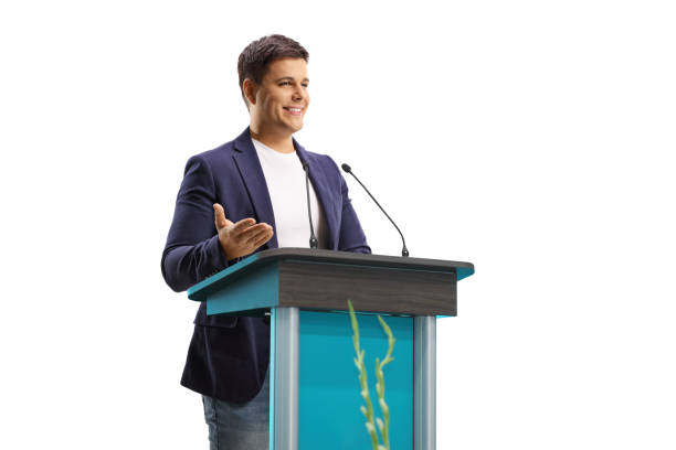 young male speaker giving a speech on a pedestal - podium lectern microphone white imagens e fotografias de stock