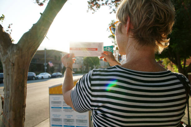 femme retenant son bulletin absent à l’urne officielle - marking voting ballot election presidential election photos et images de collection