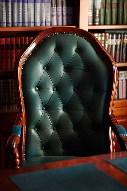 istock Dark solid interior of old library with books on the wooden shelves. 1280963920