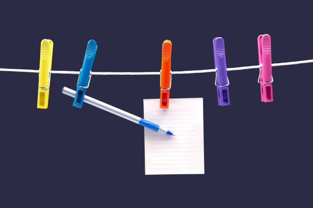 istock paper notepad for reminder and pen hanging on colored clothespins 1280965500