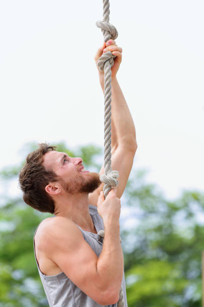 istock gym man doing rope climb workout climbing 1280969126