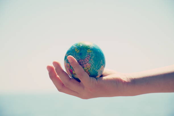 istock Personal Perspective, Child Plays with Globe Ball by Sea 1280969166
