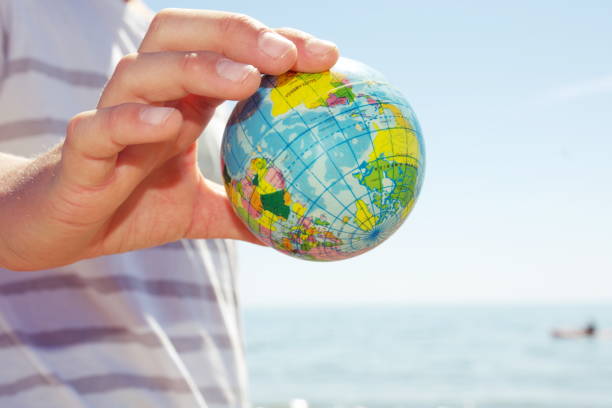 istock Personal Perspective, Child Plays with Globe Ball by Sea 1280969206