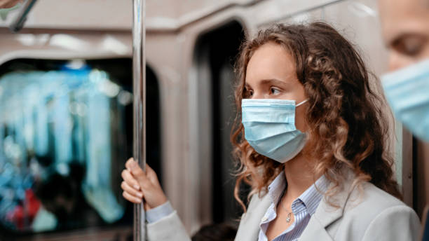 istock young woman in a protective mask standing in the subway car 1280971561