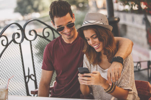 istock Smiling young couple passing time on a smart phone while waiting for their food order in restaurant 1280973342