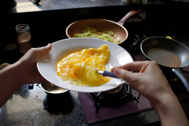 preparazione di una frittata con zucchine - folding hands immagine foto e immagini stock