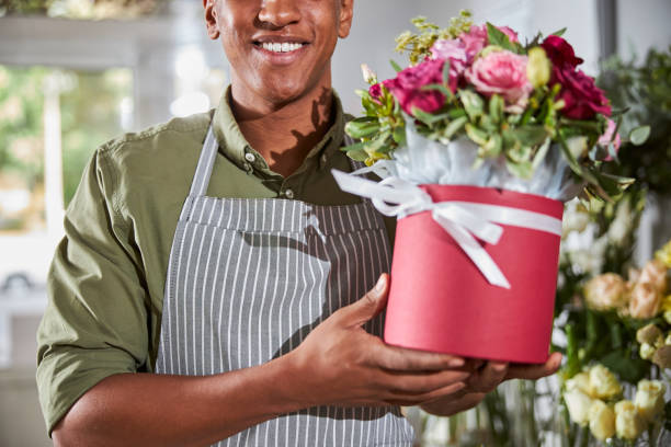 istock Mixed-race floral artist showing a flower planter 1280979320