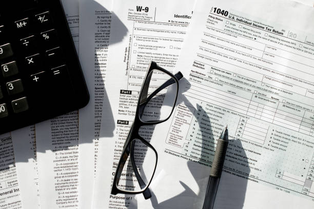 istock tax forms with the glasses, calculator and the pen. 1280981064