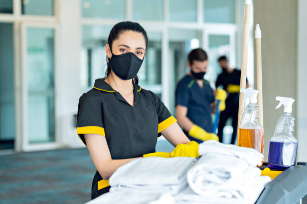 istock Three hotel cleaners cleaning common areas with their masks on. 1280984333