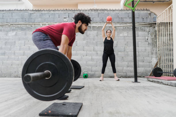 istock Young latin man about to lift bar with weights 1280986920