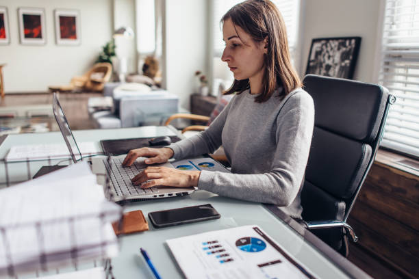 istock Woman works at a table in her home office 1280987573