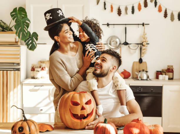 glückliche multiethnische familie mama, papa und sohn haben spaß und feiern halloween zu hause - halloween stock-fotos und bilder