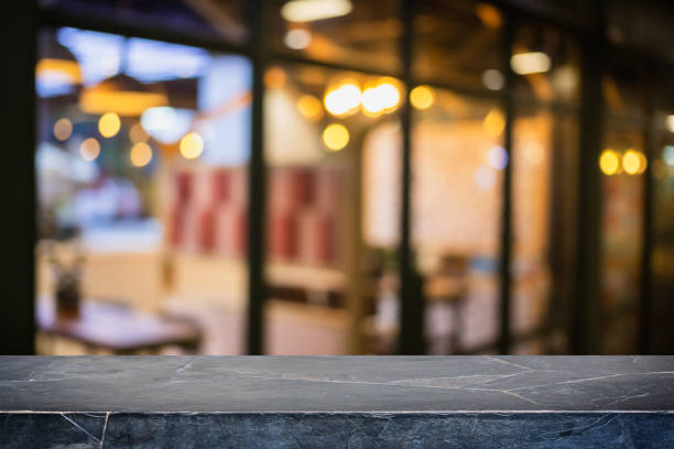 istock Empty black marble stone table top and blur glass window interior restaurant and cafe banner mock up background - can used for display or montage your products. 1280991633