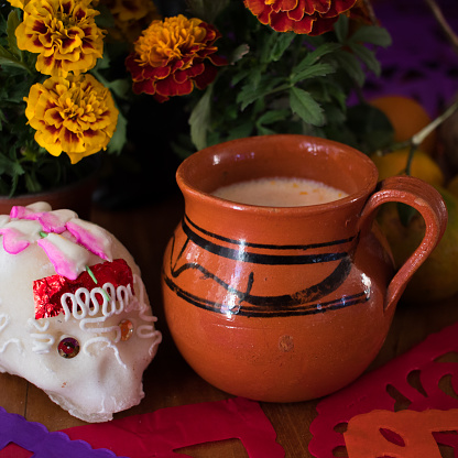 Day of the Dead Offering Jug with pulque, tangerines an cempasuchil flowers photo