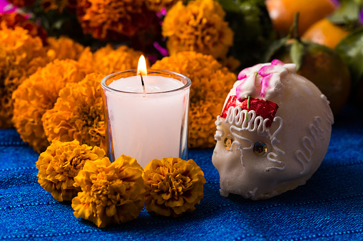 Day of the Dead candle and sugar skull whit cempasuchil flower background photo