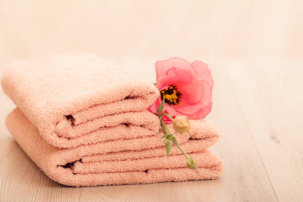 Plush spa towels with soft light of candle. Room for text