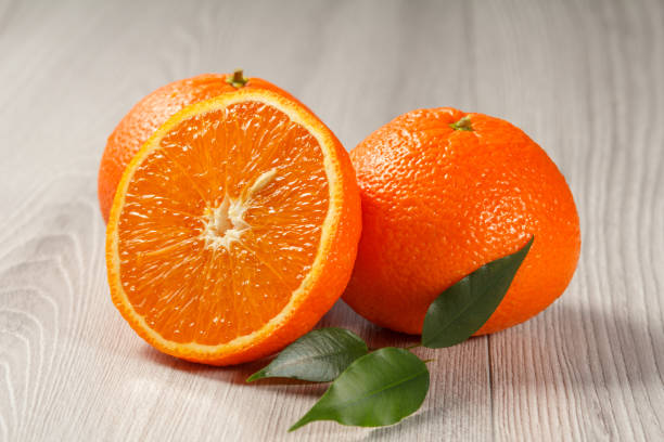 istock Cut orange in half on wooden background 1280997800